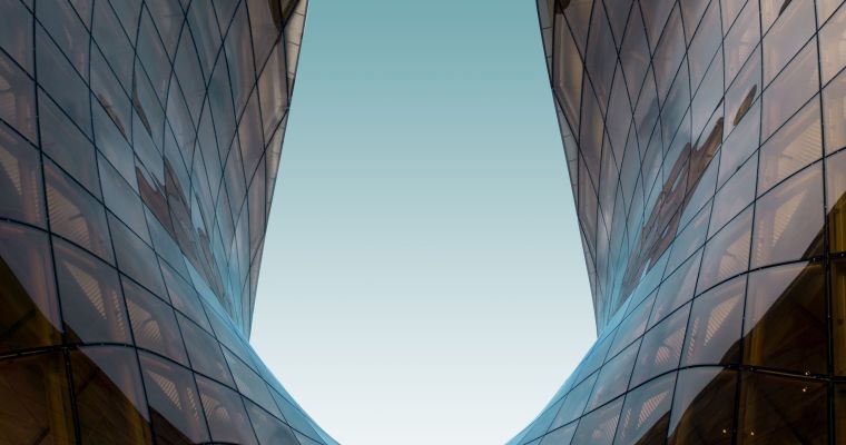 A glass U shaped structure with the blue sky in the background